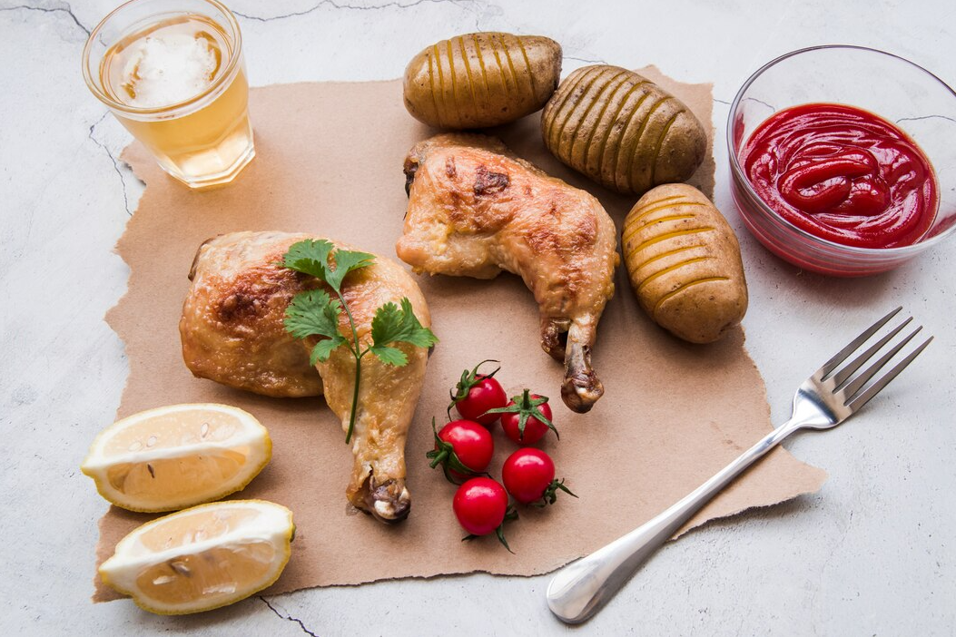 A bowl of chicken submerged in a brine solution with fresh herbs and lemon slices.