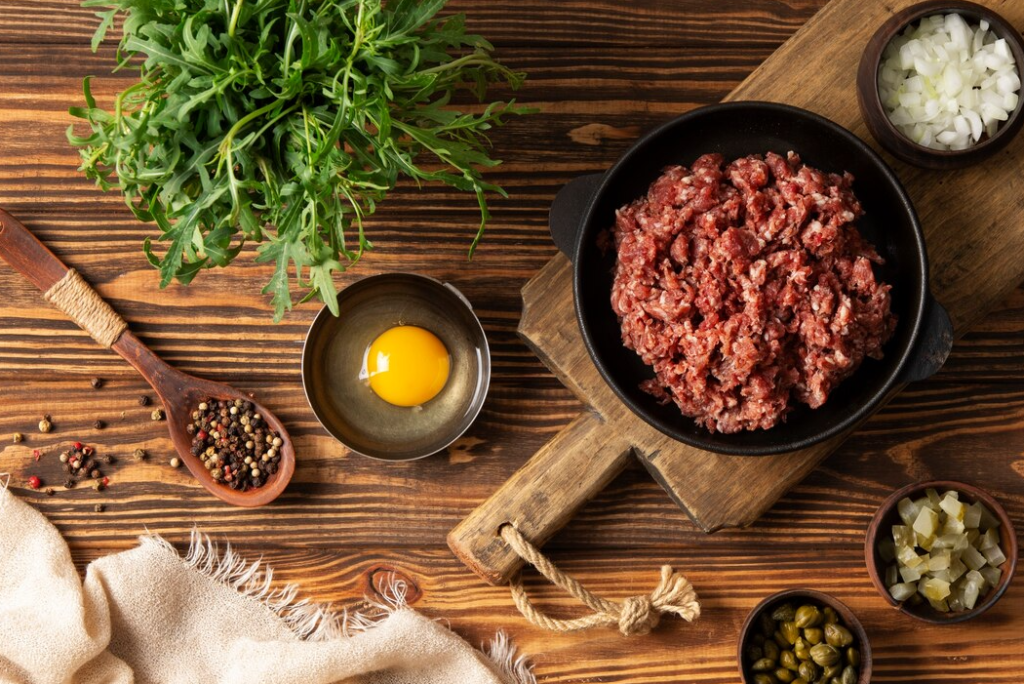 Ground beef in a skillet with fresh herbs and spices