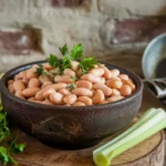 Creamy butter beans served in a bowl with herbs and vegetables